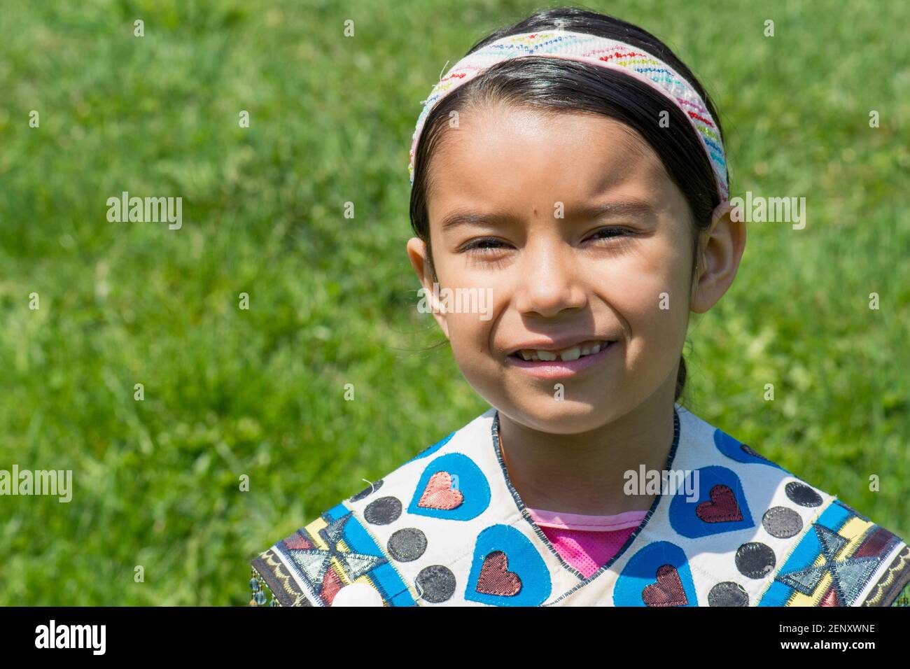 Canadian First Nation teenager girl: Portrait of Indian girls in a national dress in the sun over a green background. 200 Anniversary of the Battle of Yor Stock Photo