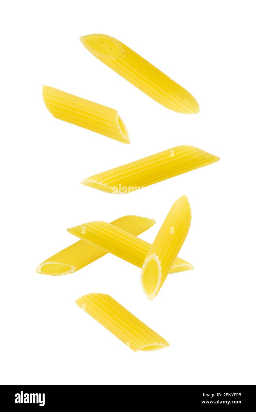 Falling penne pasta. Flying yellow raw macaroni over white background. Stock Photo
