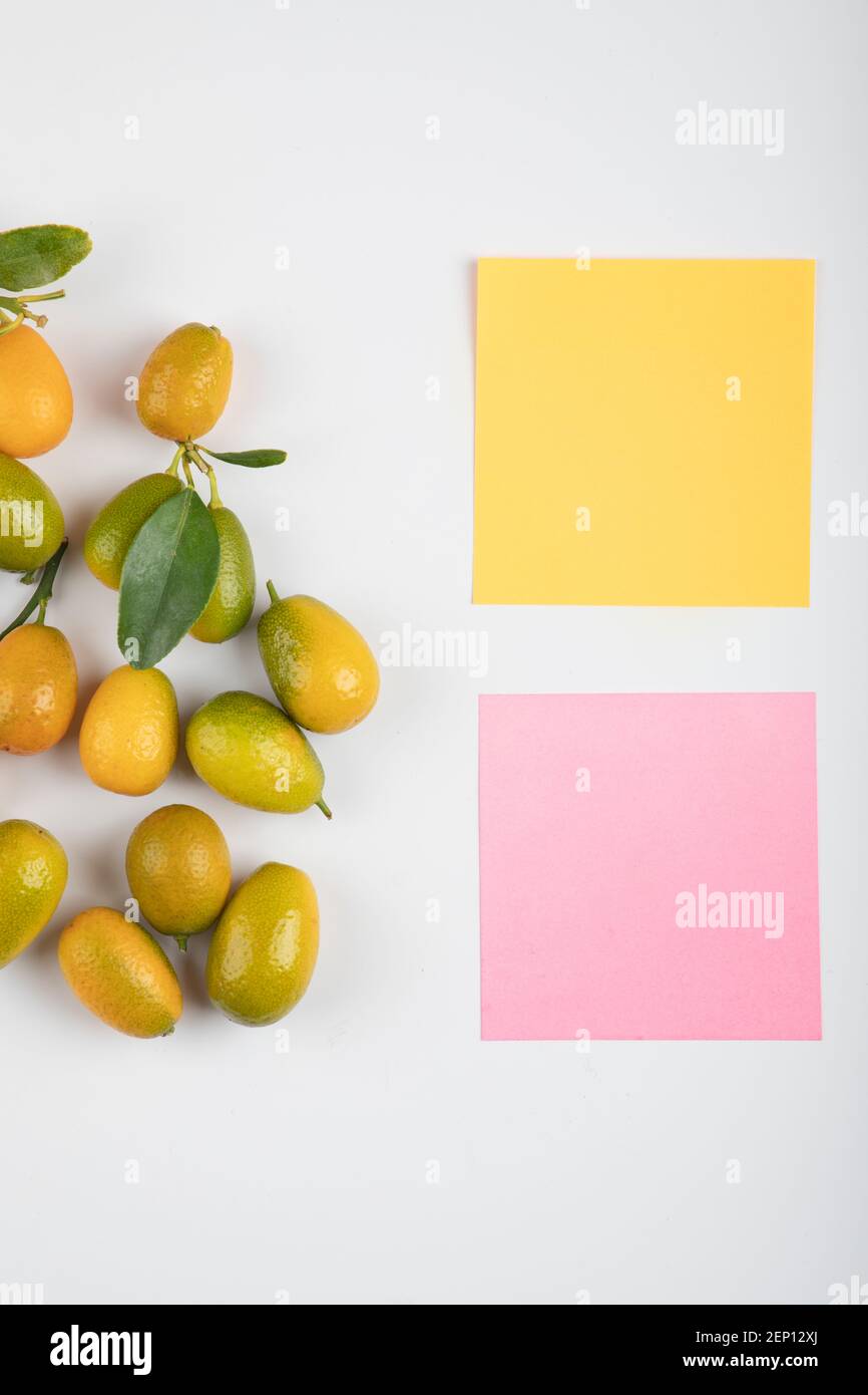 Yellow kumquats with leaves and memo pads on white background Stock Photo Alamy