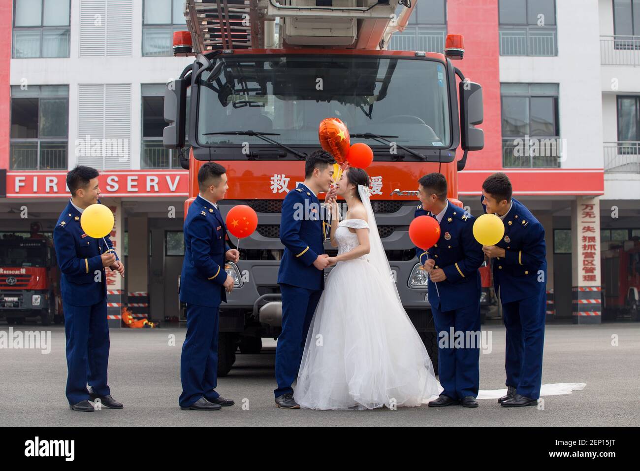 Fireman Jia Jie and his wife take unique pictures with the help of his colleagues in front of a fire fighting truck in Chengdu city, southwest China's Sichuan province, 9 October 2019. Stock Photo