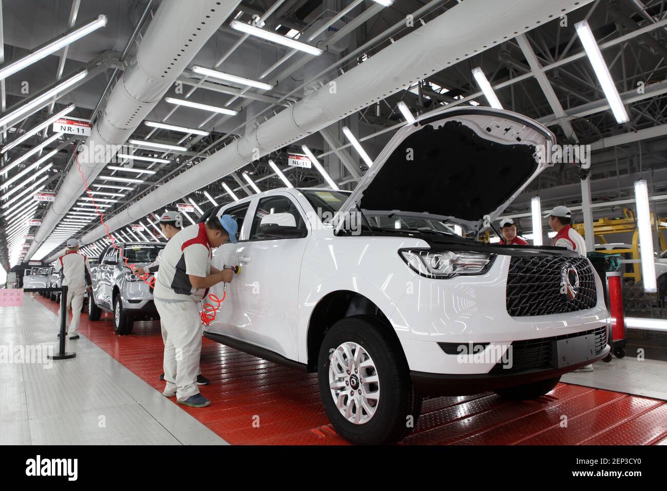 Chinese workers assemble cars on the assembly line at the auto plant of ...