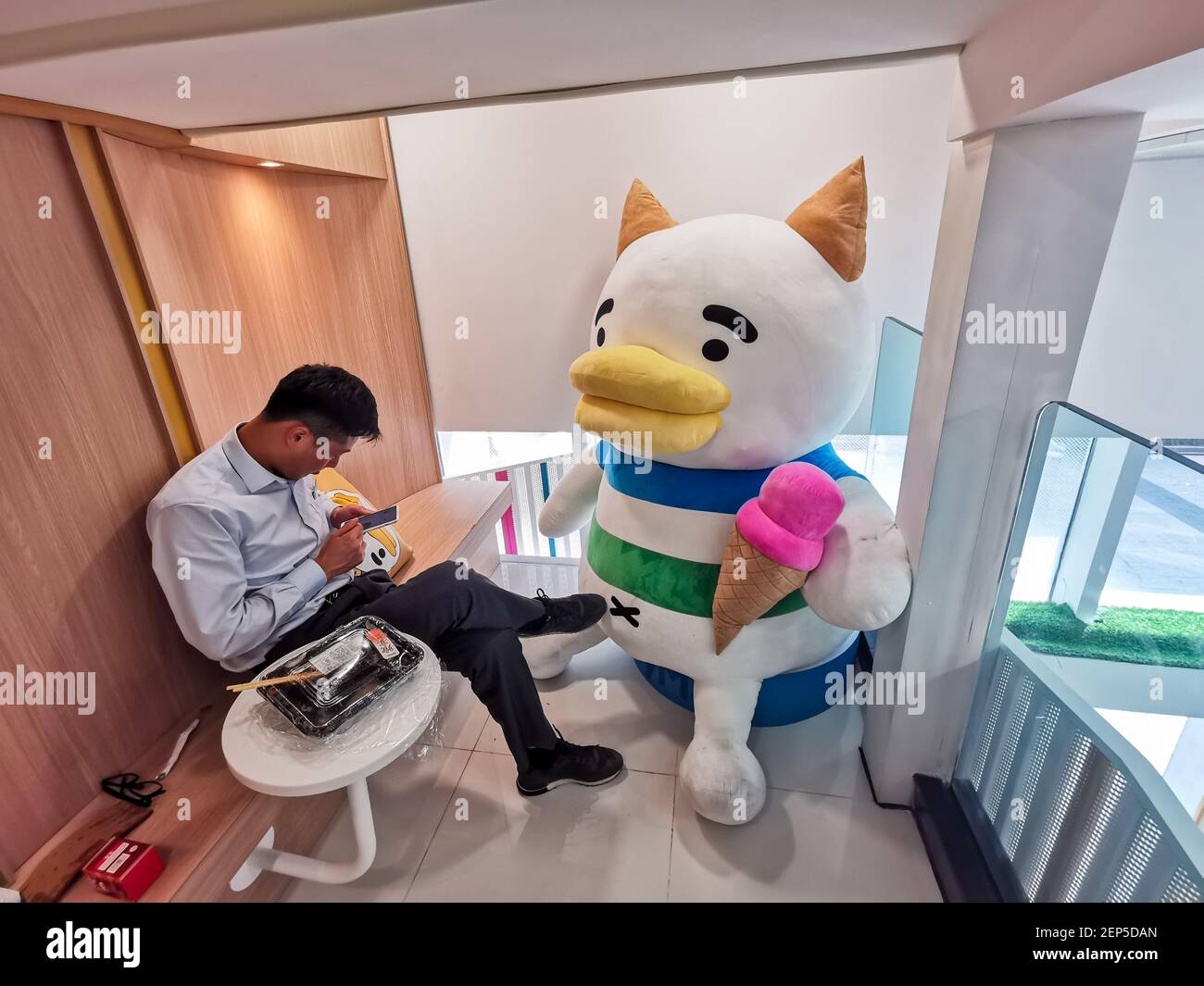 A person site by a giant stuffed animal at the Biang!Biang!Cat