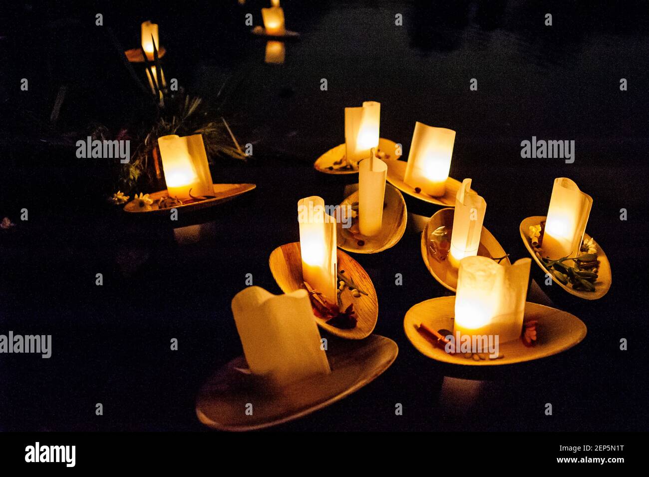A group of candles float at the lake. Hundreds of people gathered
