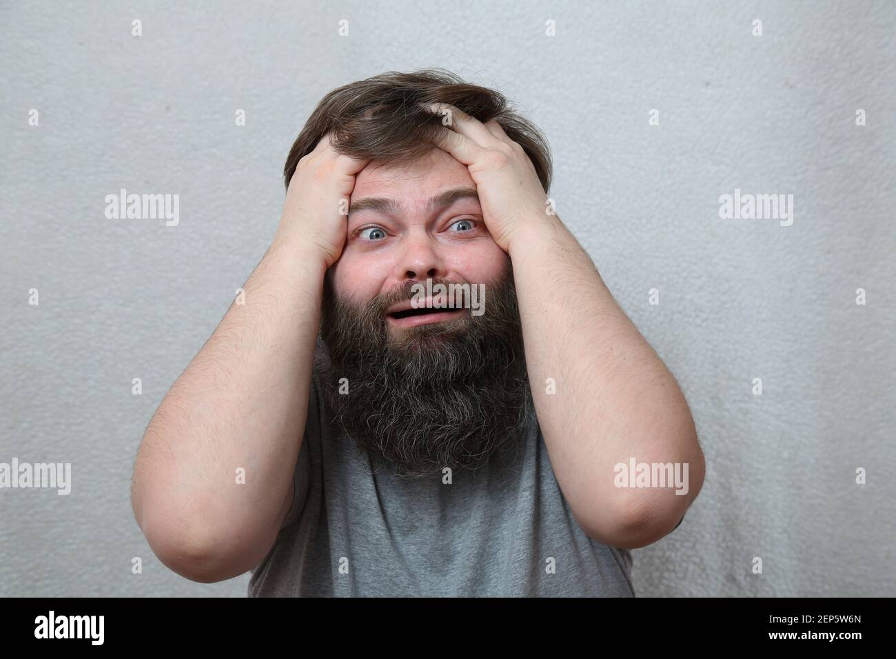 A man with a beard in a tantrum Facial expression of panic, fear, failure Concept: business collapse, bankruptcy, stress, defeat. Humor, a joke. Stock Photo