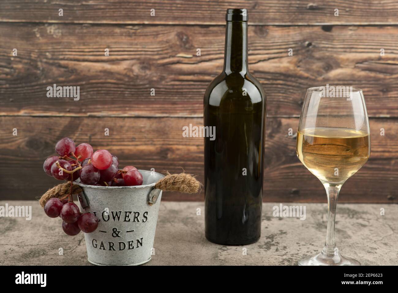 Metal bucket of red fresh grapes with bottle of white wine on marble table Stock Photo Alamy