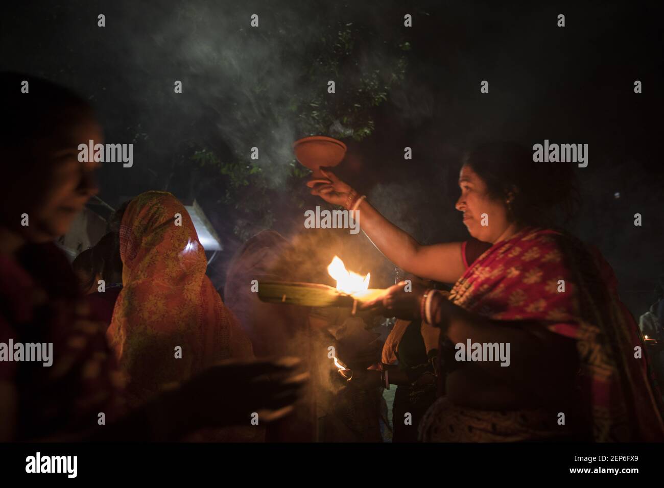Hindu Devotees Sit On The Floor To Worship With Prodip And Candle Lights Pray To God In Front Of Shri Shri Lokanath Brahmachar Ashram And During Their Fasting Program Called Kartik Brati