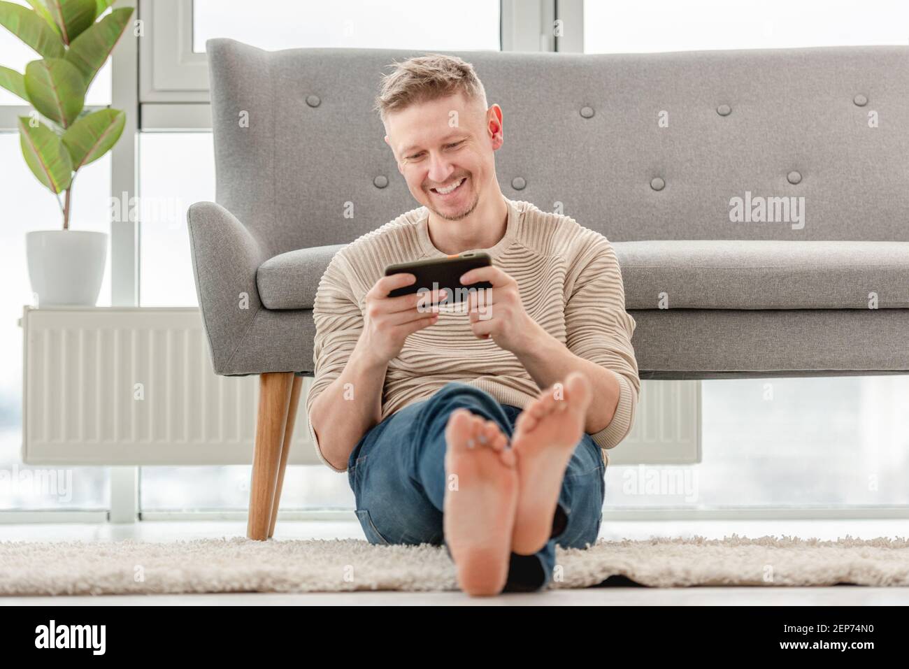 Man plays games on smartphone Stock Photo