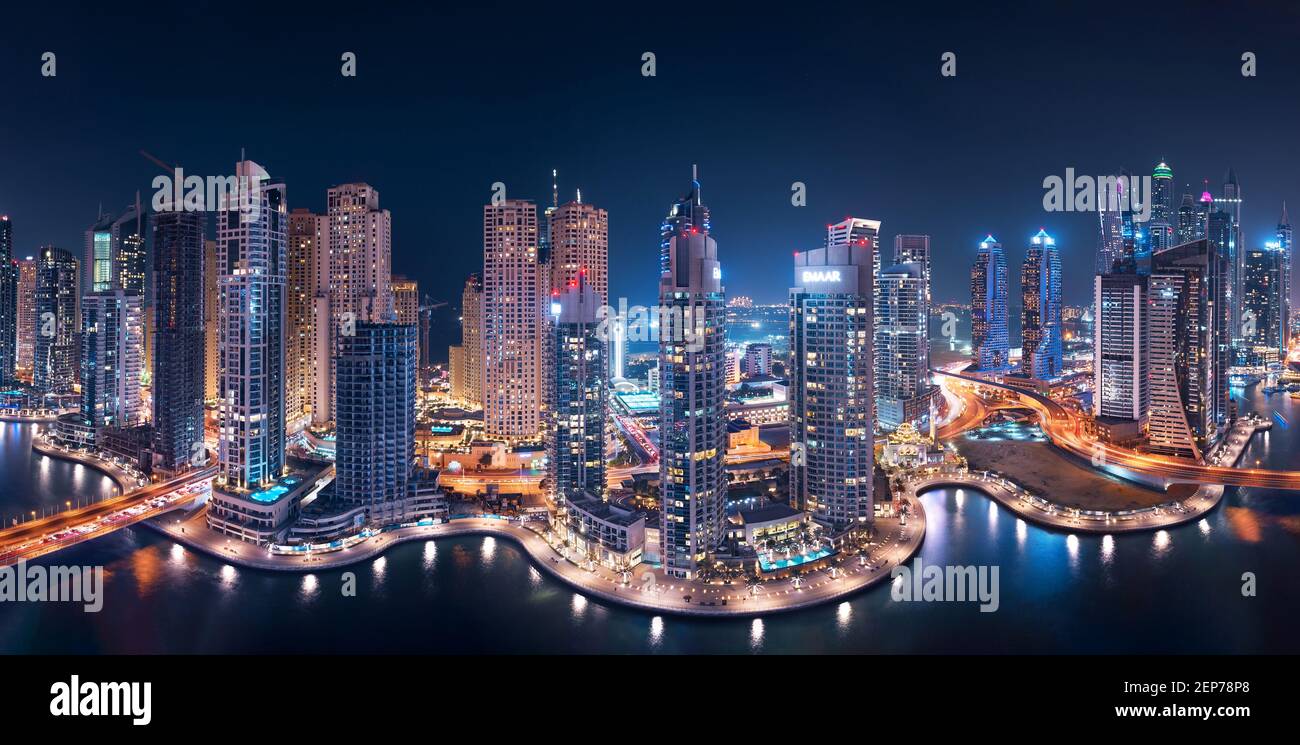 Dubai Marina Towers Glowing at night in a panoramic view with Atlantis the Palm in the background Stock Photo