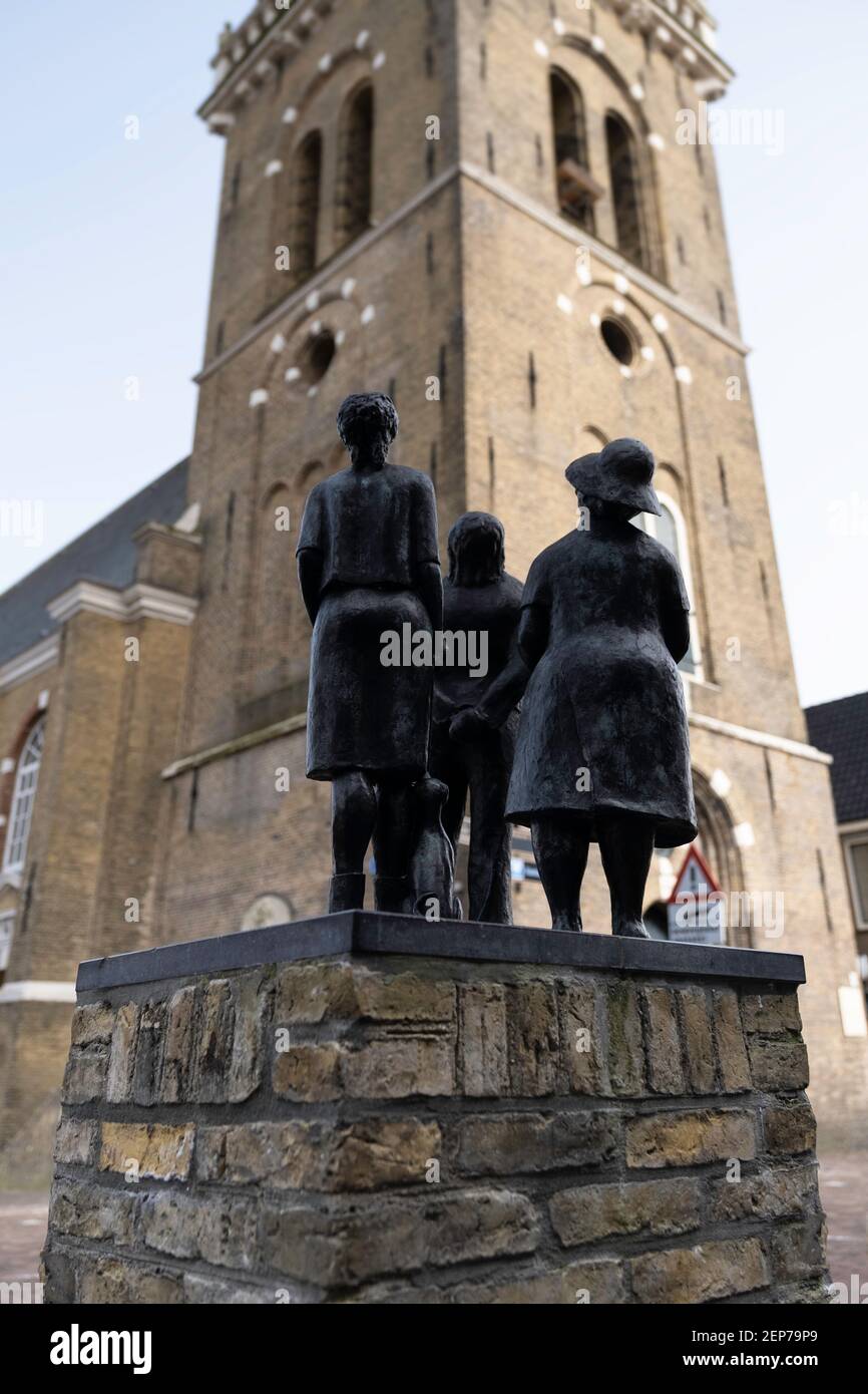 Sculpture of a family looking up at the tower of the 'Hobbe van Baerdt' Church in Joure. Made by Annet Haring. Focus on the back of both females Stock Photo