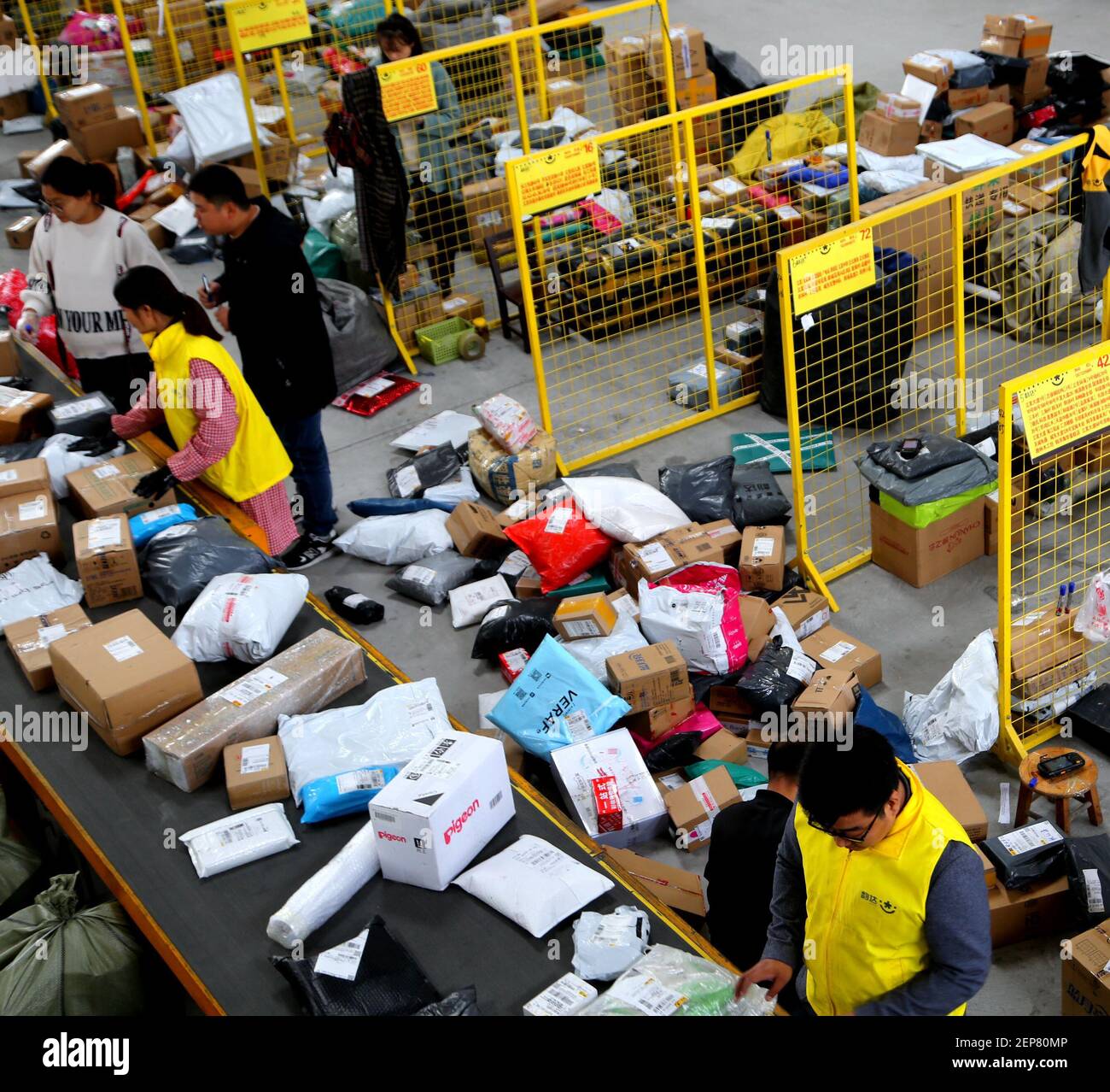Workers at a logistics center sort out parcels as Double 11 delivery ...