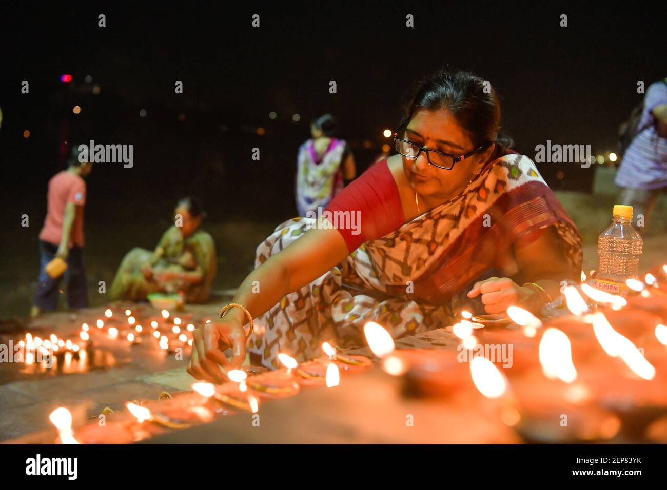 A woman is seen lighting up the steps of the ghat of Ganges to perform the rituals on Dev