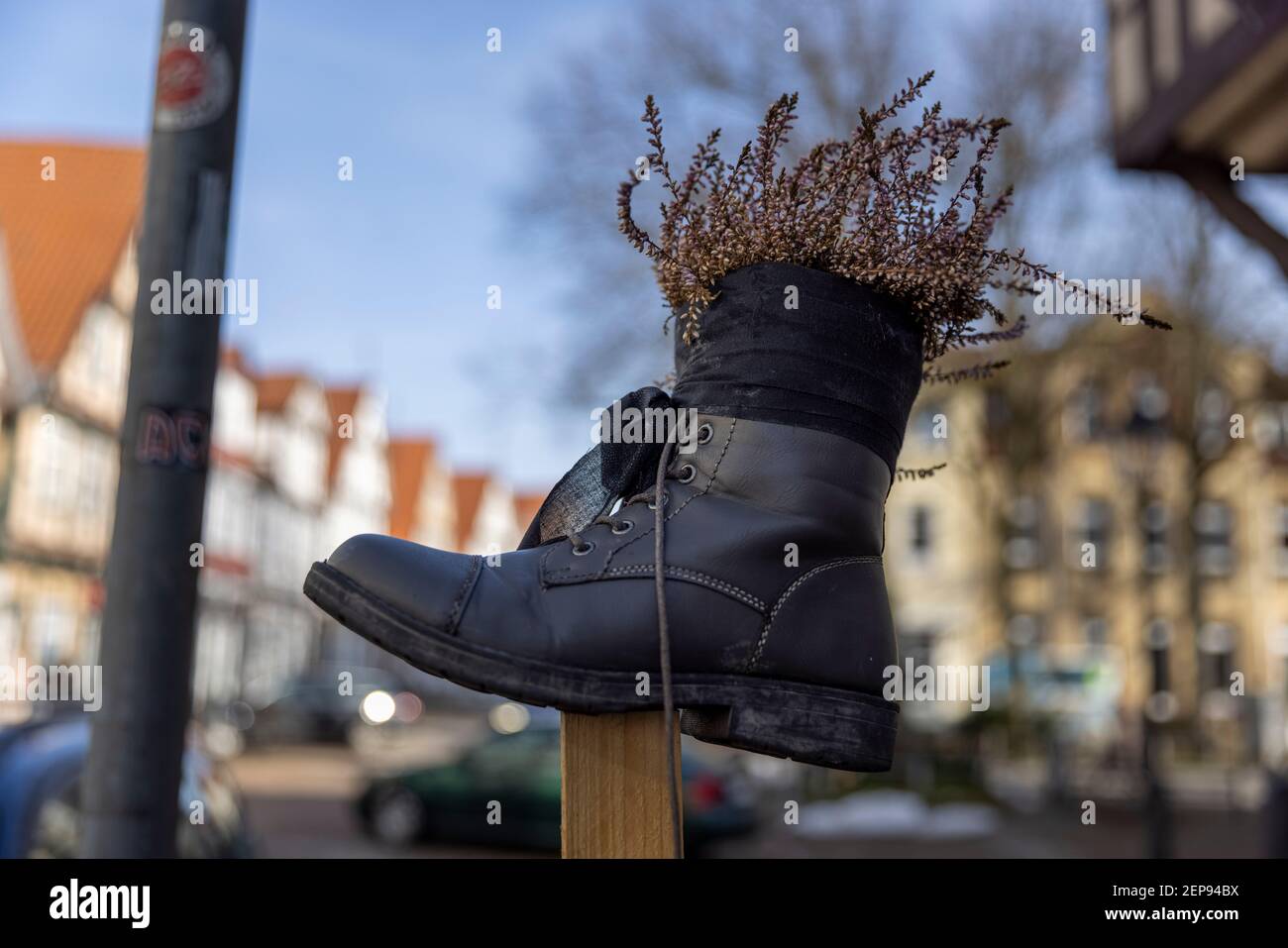 German city Celle is waking up after short winter. Flowers are planted in old shoes in old town. Stock Photo
