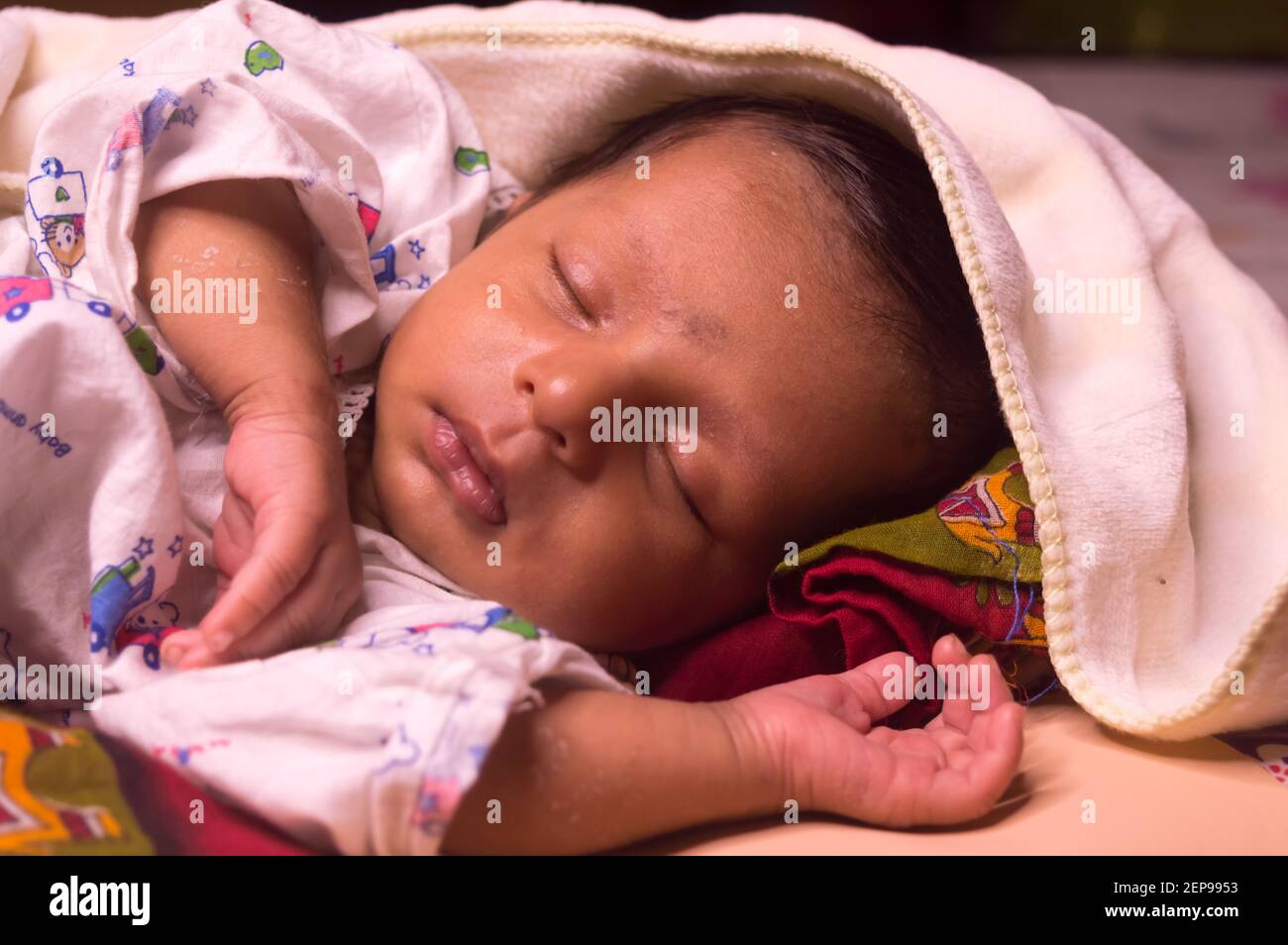 Close up face of cute sleeping newborn baby boy in drowsy eyes with sleepy mood. One month old Sweet infant toddler Closeup portrait. Indian ethnicity Stock Photo