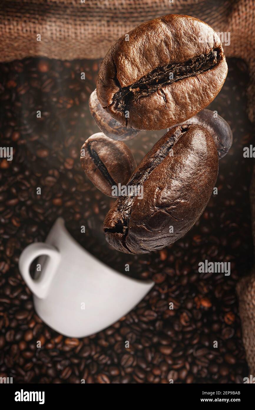 background with coffee beans falling on a cup of coffee Stock Photo - Alamy