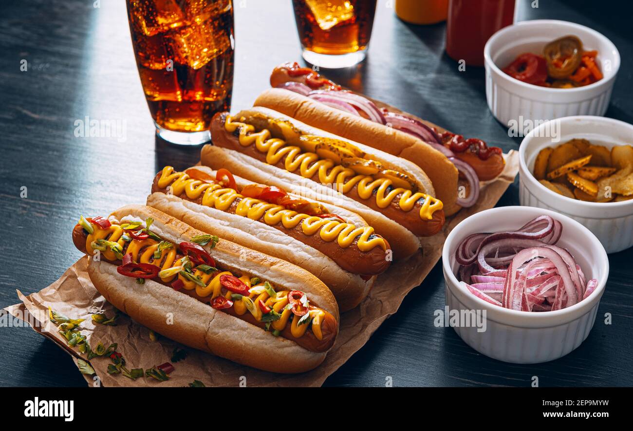 American hot dog with ingredients on a dark wooden background Stock