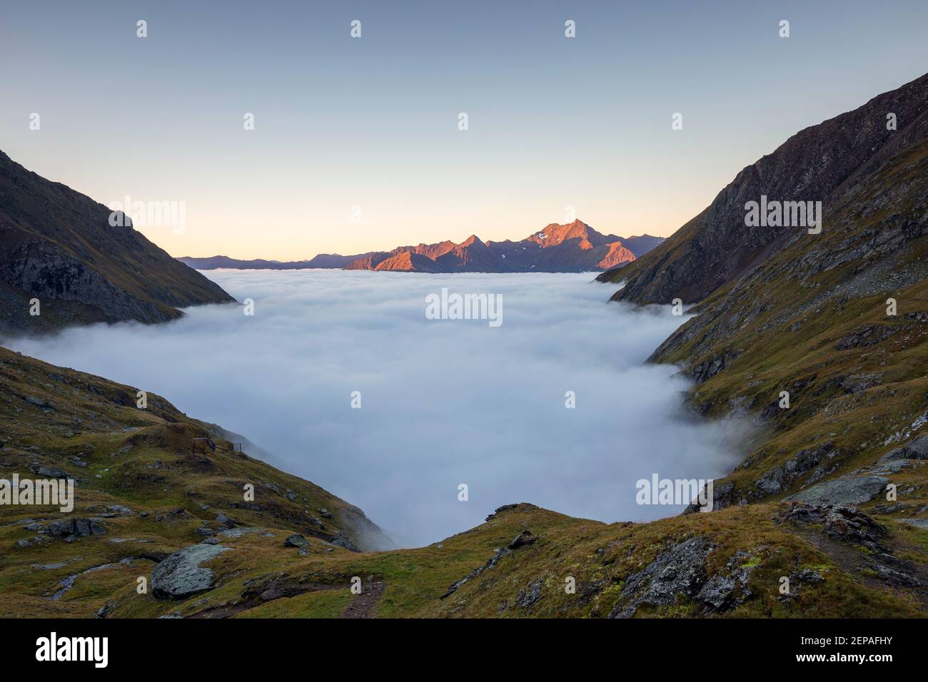 At sunrise, view on Timmeltal valley, in background Lasörling peaks. Tide of clouds. Austrian Alps. Europe. Stock Photo