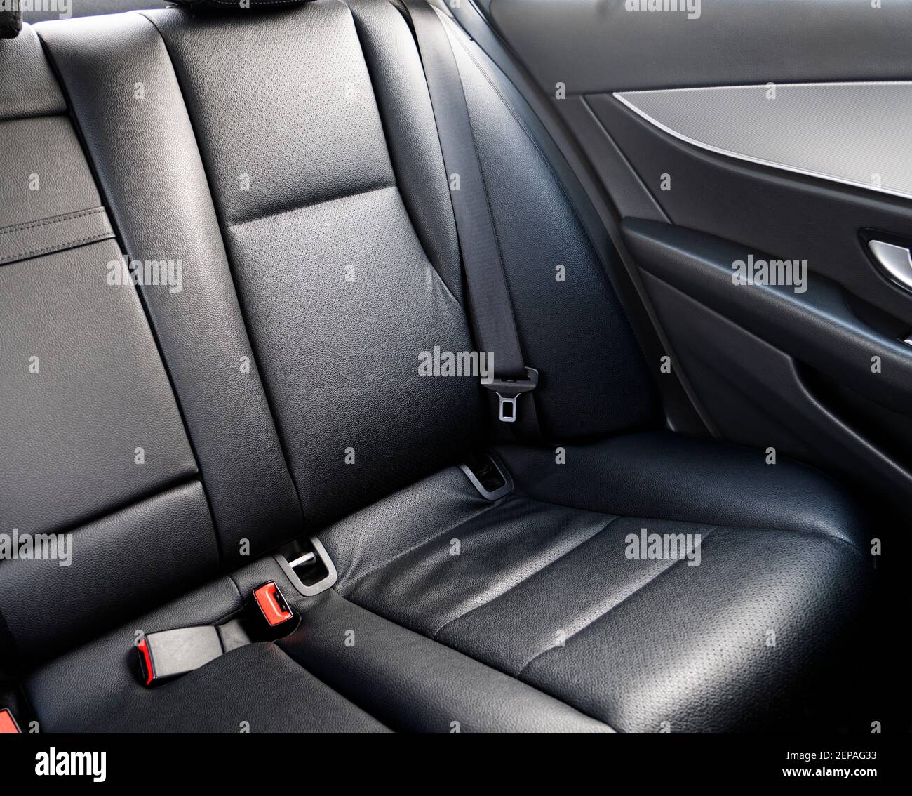 Back passenger black leather seats in modern luxury car. Black perforated leather with stitching. Car inside. Leather comfortable red seats. Car inter Stock Photo
