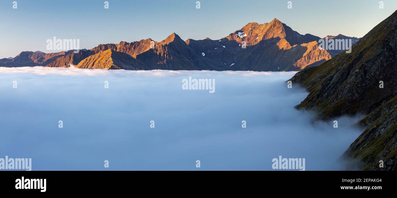 View on Berger Kogel, Lasörling mountain group. Sunlight at sunrise. Tide of clouds over Timmeltal and Virgental valleys. Austrian Alps. Europe. Stock Photo
