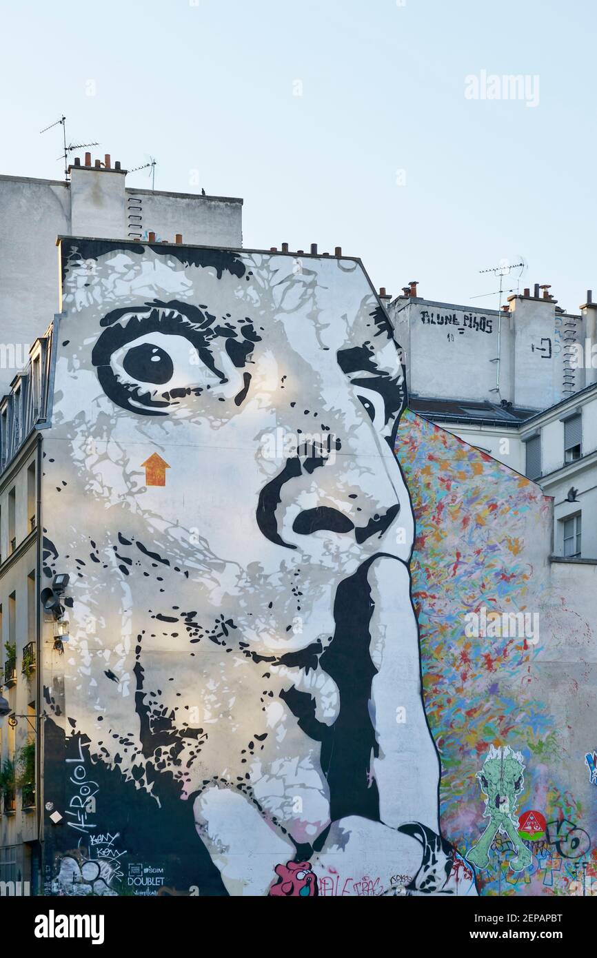 A giant face indicating 'shhh' graffiti'd on the side of a building in Paris, France, Europe. Stock Photo