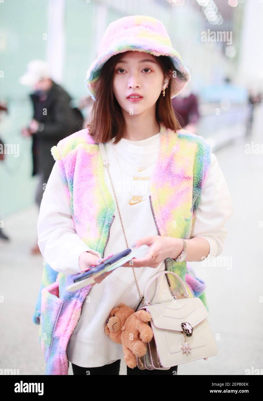 Wu Xuanyi of Chinese idol girl group Rocket Girls 101 arrives at a Beijing  airport before departure in Beijing, China, 25 November 2019. Hoodie: Nike  Vest: A Piece of Cake Bag: Bvlgari