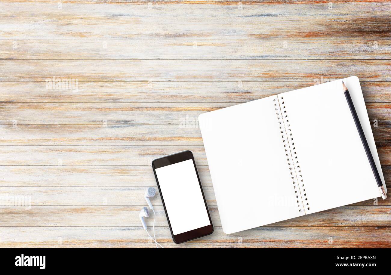 Office desk table with blank screen smartphone,notebooks and pencil