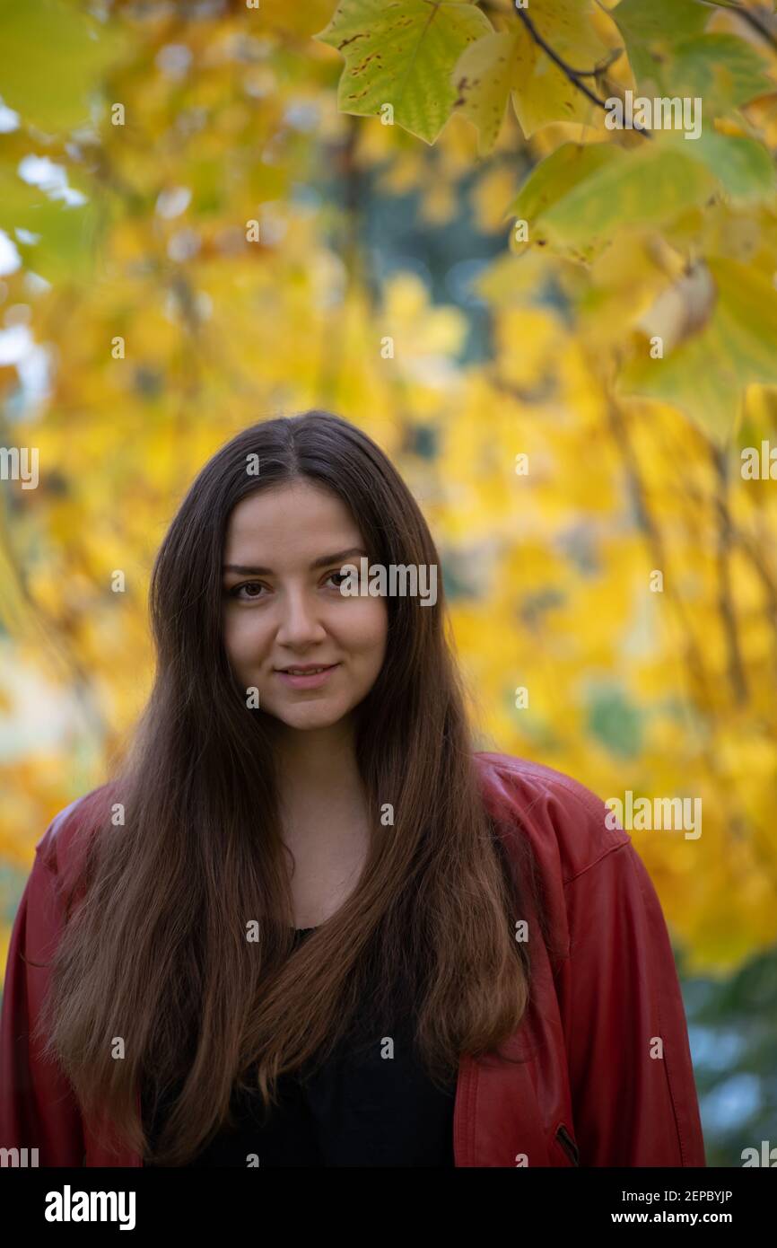 Portrait of a young smiling woman in autumn park Stock Photo - Alamy