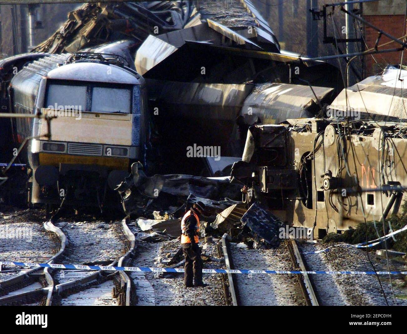 File photo dated 01/03/01 of a policewoman walking across the track with the wreckage of the trains behind at the scene in Great Heck near Selby, North Yorkshie, where two train drivers, two others GNER staff and six passengers died on February 28 2001, after the Newcastle to London passenger service struck a Land Rover which had careered off the M62 motorway and crashed onto the track. Issue date: Saturday February 27, 2021. Stock Photo
