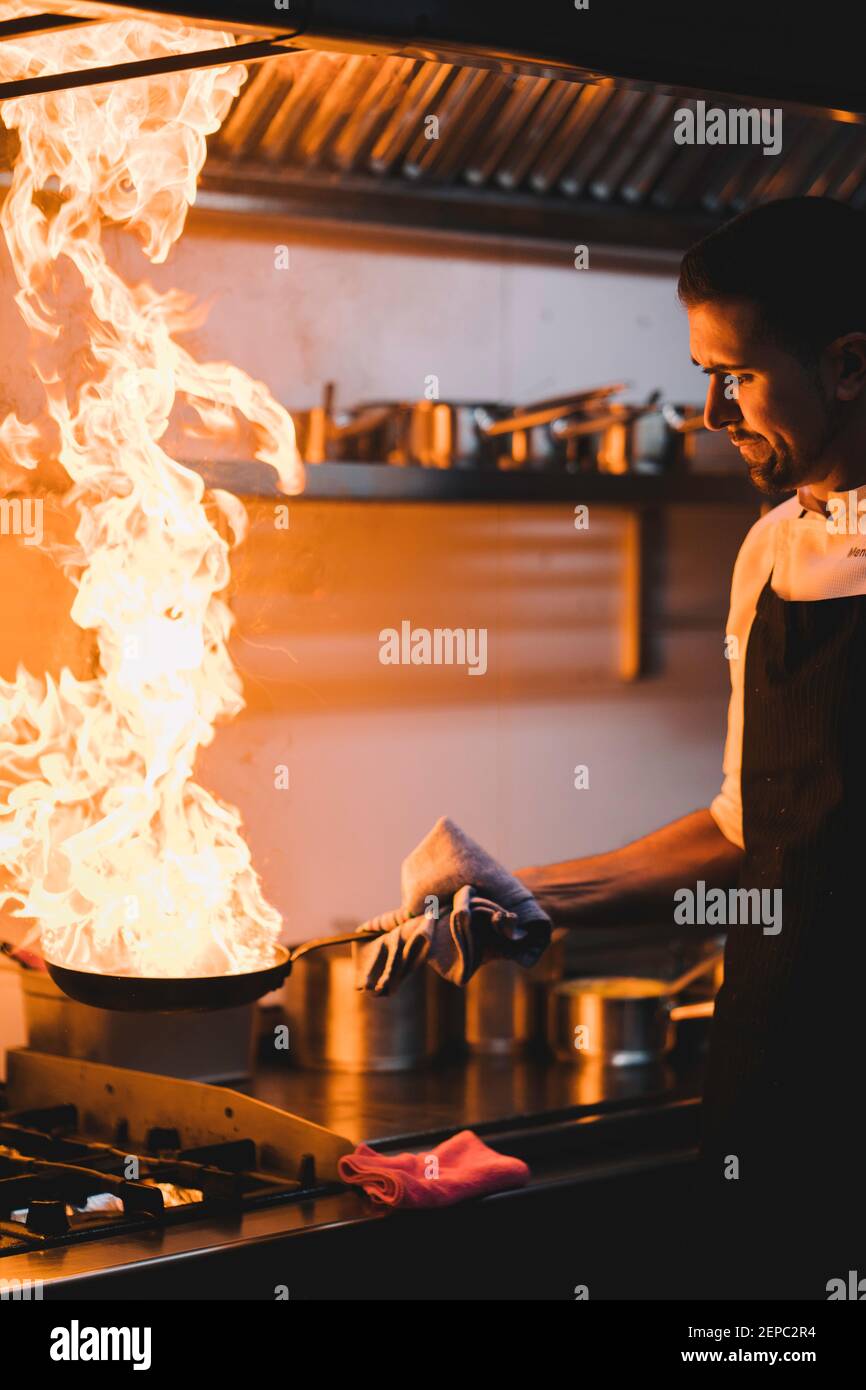 https://c8.alamy.com/comp/2EPC2R4/portrait-of-a-professional-chef-sauting-ingredients-in-a-pan-with-large-flare-of-oil-2EPC2R4.jpg