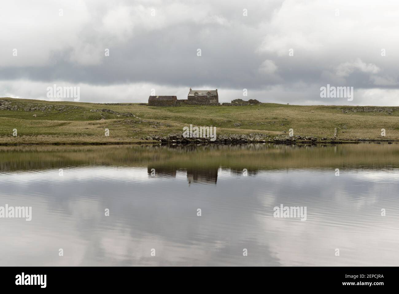 An old isolated house beside a loch at Esha Ness, Shetland. Stock Photo