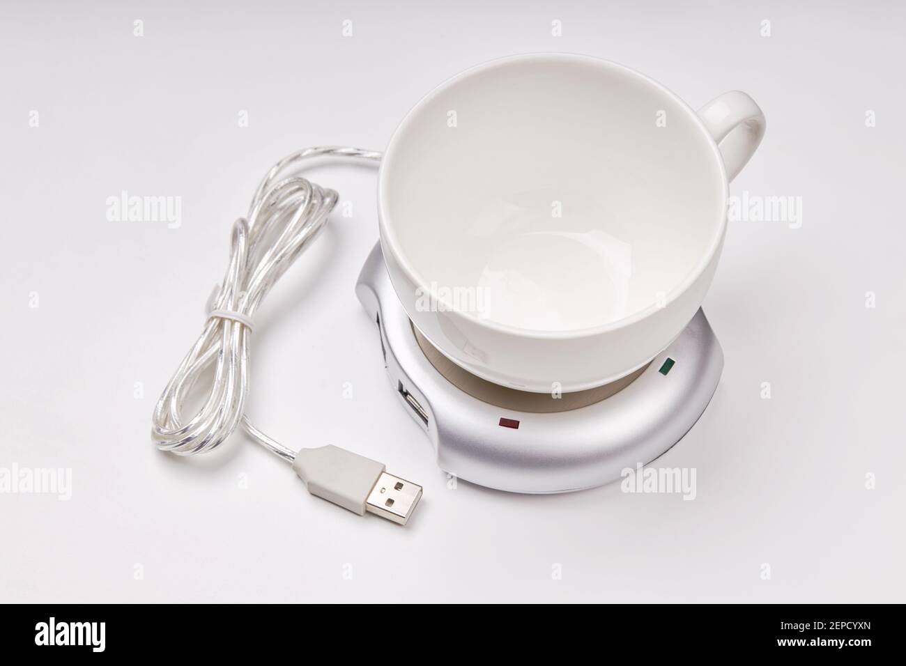 electronic usb hub and heater for cup coffee or tea at office. digital usb warmer device on grey background. Stock Photo