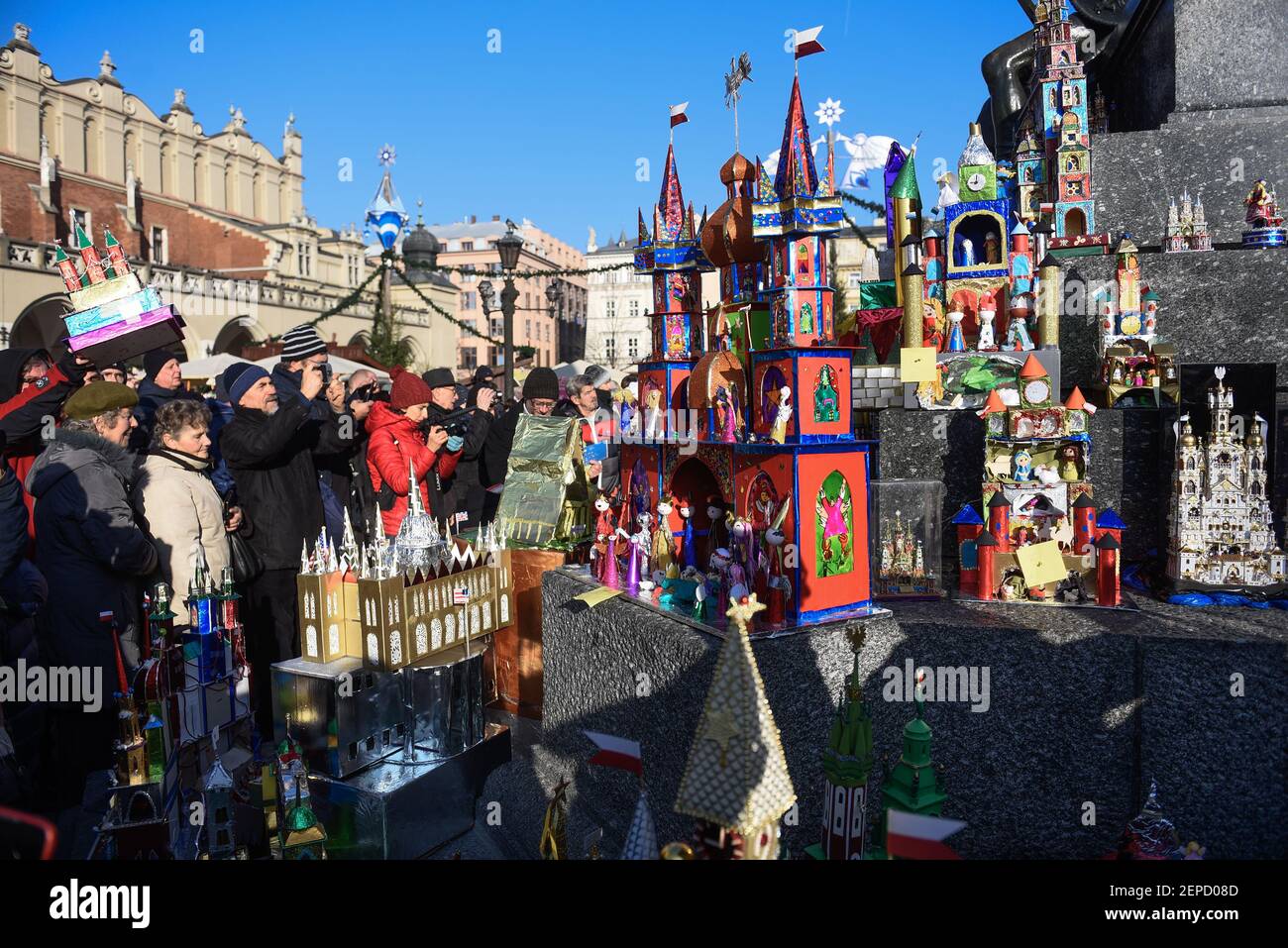 People stand next to nativity scenes during the 77th edition of ...