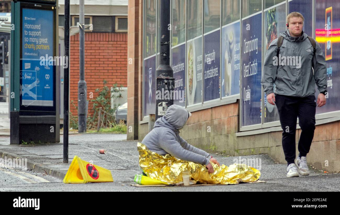 Glasgow, Scotland, UK, 27th February, 2021, Lockdown Saturday saw rainy weather as people continue to wander alone aimless in the empty city centre. The homeless beggers have largely given up due to so few people on the streets with the few remaining hitting the inner town supermarkets which have customers.  Credit Gerard Ferry/Alamy Live News Stock Photo