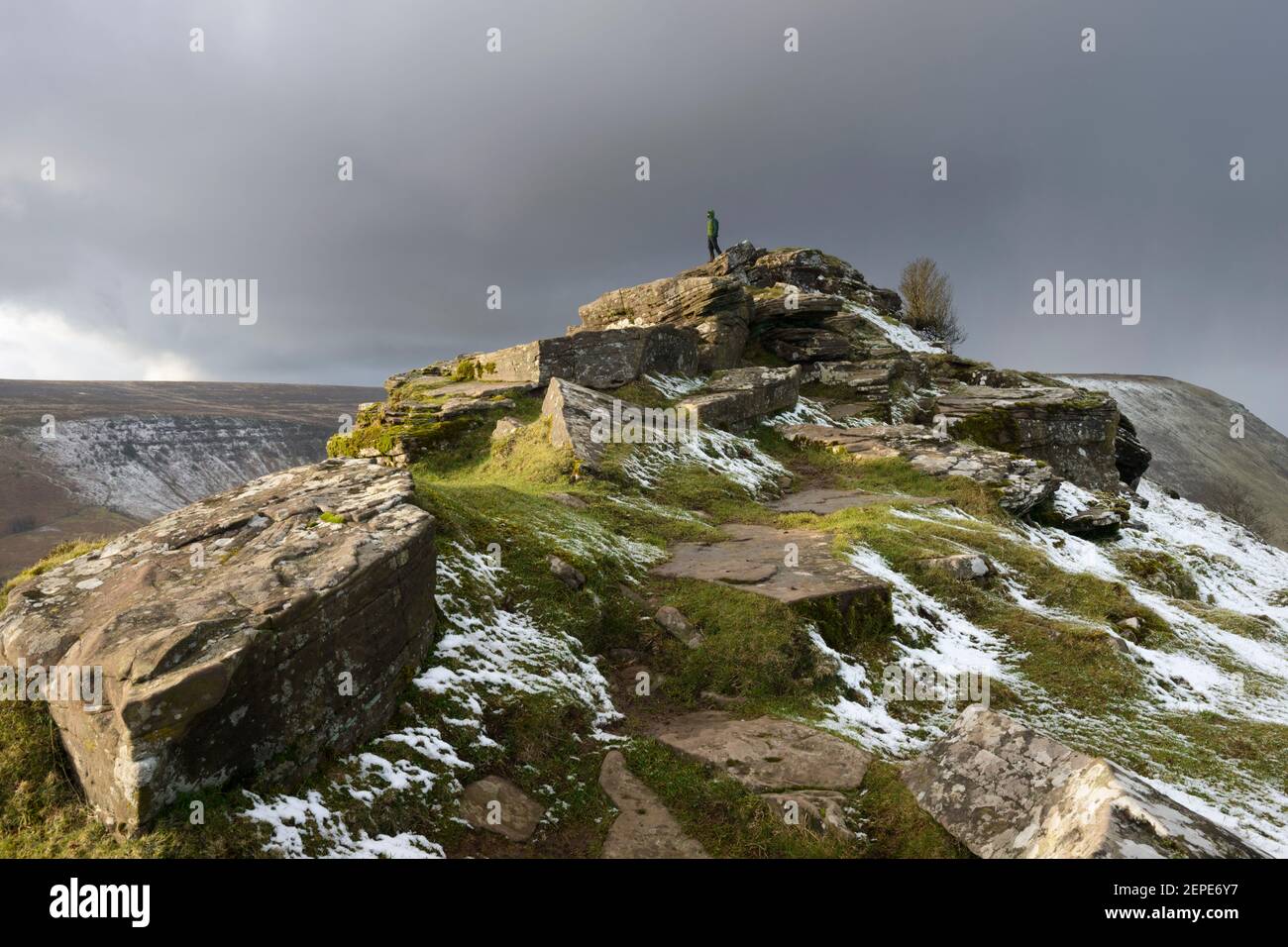 A male hiker looks into the distance from the top of Cat's Back on the Welsh/English border in Herefordshire. Stock Photo
