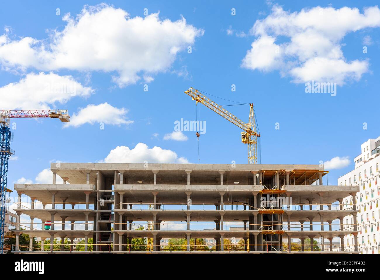 Apartment building construction. industrial cranes at blue sky Stock Photo