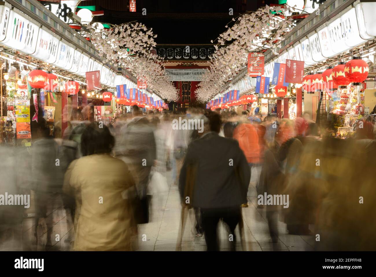 People walking through a street market at night in Asakusa, Tokyo, Japan. Stock Photo