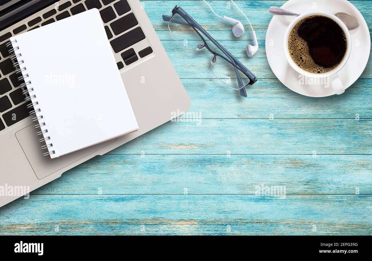 Office desk with laptop, coffee and glasses on wooden table background.  Workplace. Top view with copy space Stock Photo - Alamy