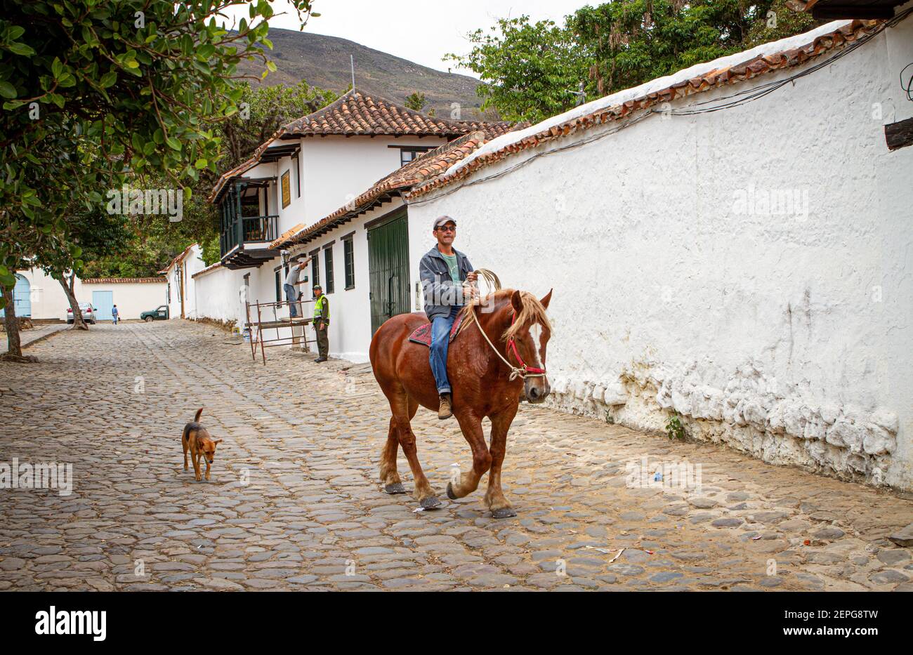 Colombian farmer. man on horse with dog. Villa de Leyva main square 500 year old town. Mountain range. Boyaca, Colombia, Colombian Andes,South America Stock Photo