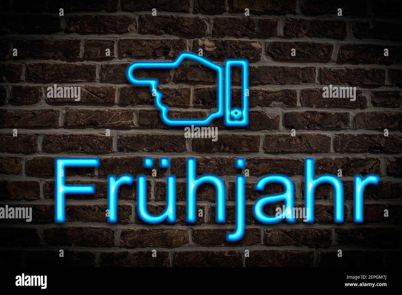 Detail photo of a a neon sign on a wall with the inscription Frühjahr (Spring) Stock Photo