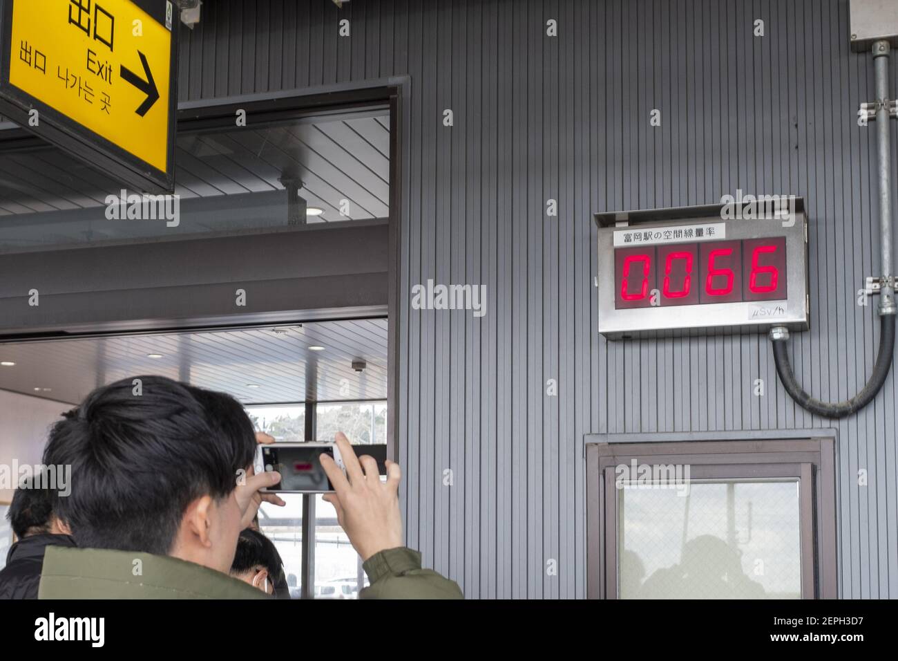 A man is taking picture of a geiger counter, which measures the current