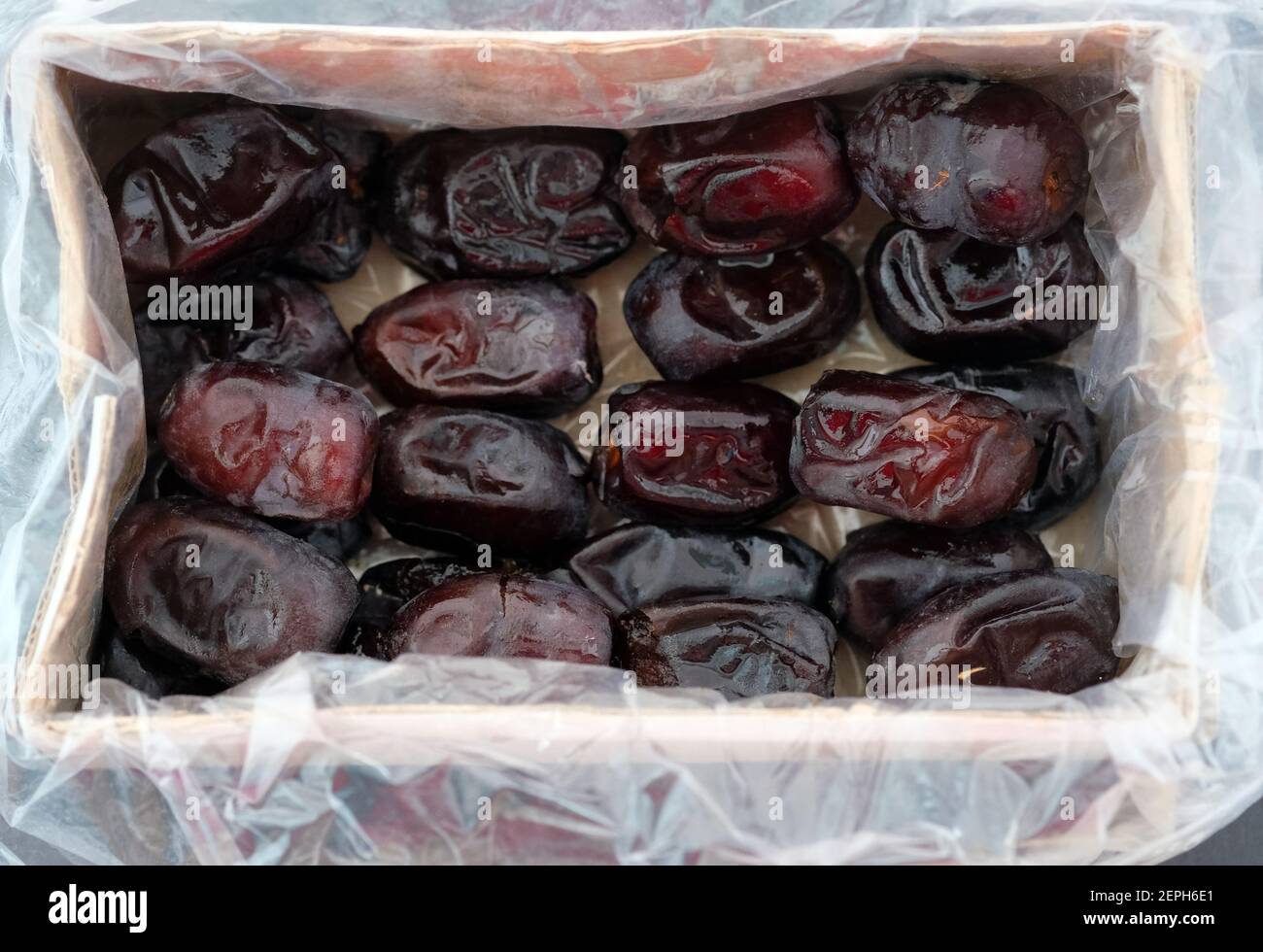 Large dates in a cardboard box top view. Packaged Iranian dates. Dried