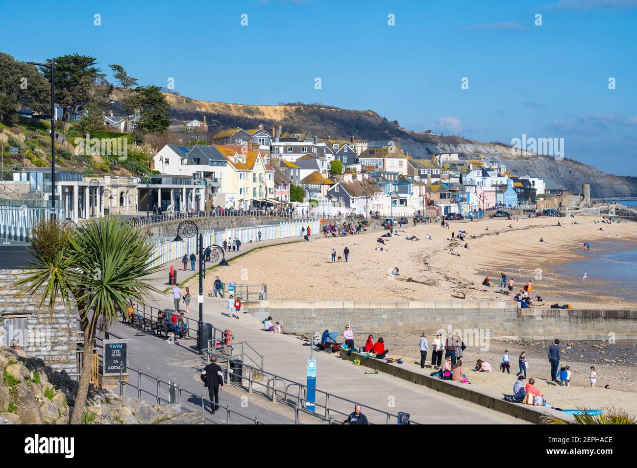 Lyme Regis, Dorset, UK. 27th Feb, 2021. UK Weather: Plenty of people were out and about enjoying unseasonably warm and sunny weather at the seaside resort of Lyme Regis this afternoon. Credit: Celia McMahon/Alamy Live News Stock Photo