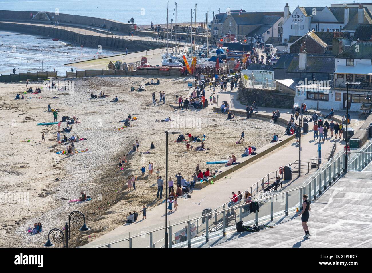 Lyme Regis, Dorset, UK. 27th Feb, 2021. UK Weather: Plenty of people were out and about enjoying unseasonably warm and sunny weather at the seaside resort of Lyme Regis this afternoon. Credit: Celia McMahon/Alamy Live News Stock Photo