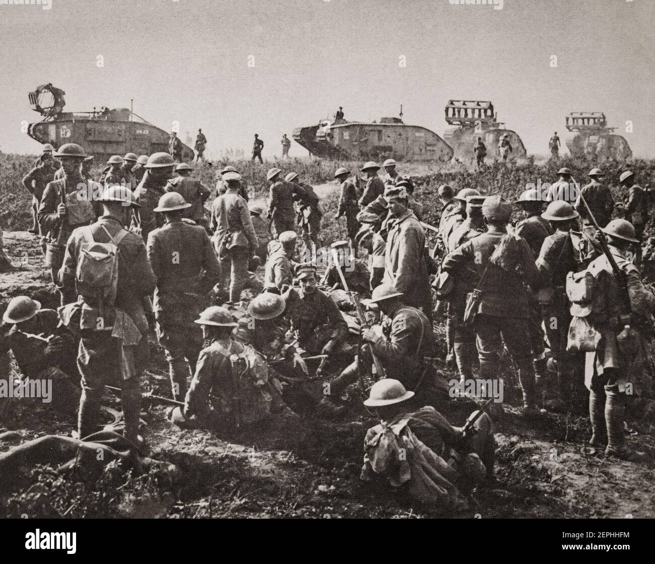 Men of the American 30th Division at rest with German prisoners following the capture of Bellicourt, 29 September 1918. In the background are British Mark V tanks (with 'cribs' for crossing trenches) of the 8th Battalion, Tank Corps, which was one of four battalions of the 5th Tank Brigade allotted to the 5th Australian Division and American Corps for the operation. Stock Photo