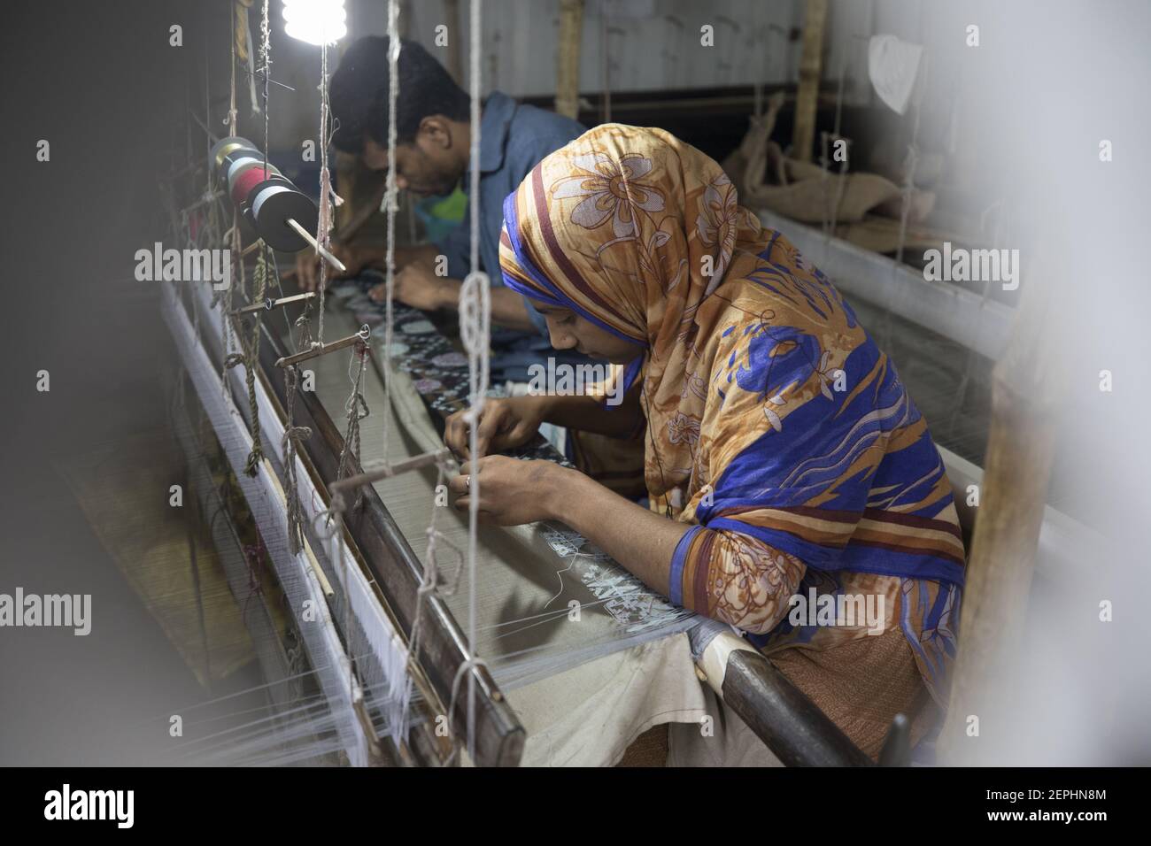 Handloom weaver weaves Jamdani saree on a traditional wooden hand ...