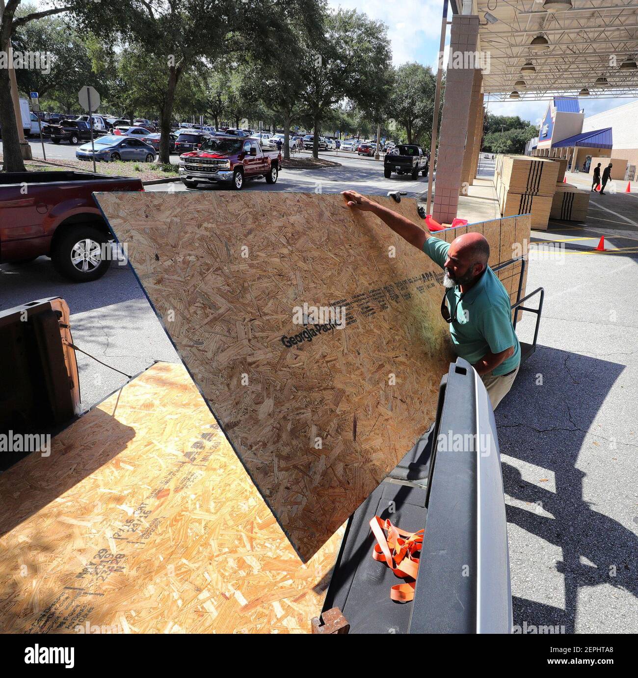 A Lowes customer loads plywood in his truck at the hardware store in
