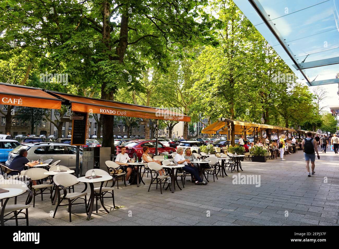 The famous luxury shopping boulevard 'Königsallee' in Düsseldorf with street cafés on a summer day. Stock Photo