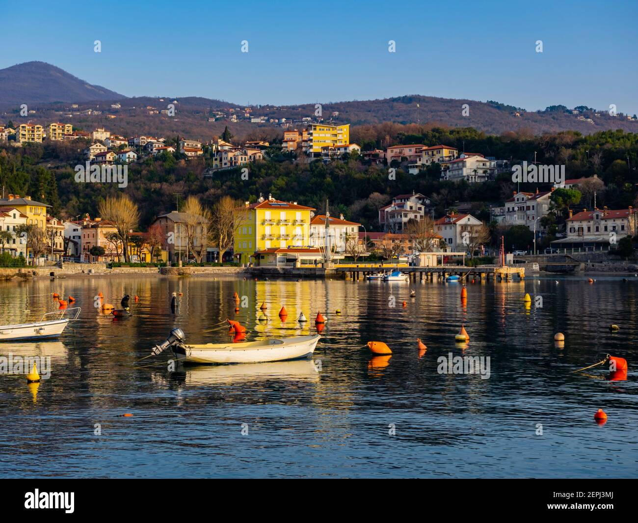 Seaside promenade in Ika in Croatia Europe moored boats boat vessels in harbor port Stock Photo