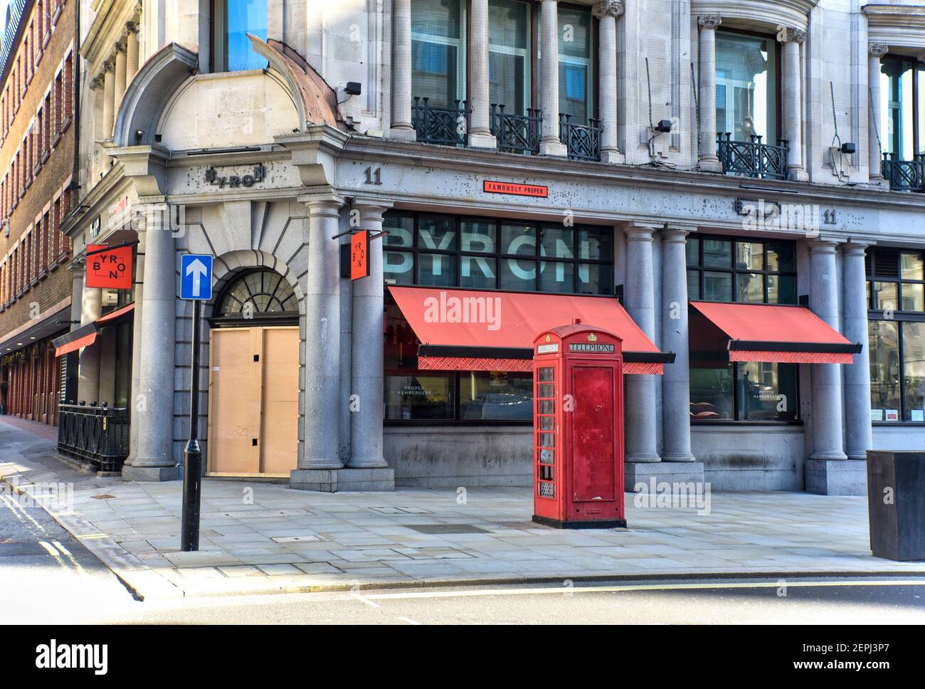 A Byron burger restaurant with its door boarded up in London remains closed during the third national lockdown due to the Coronavirus pandemic. Stock Photo