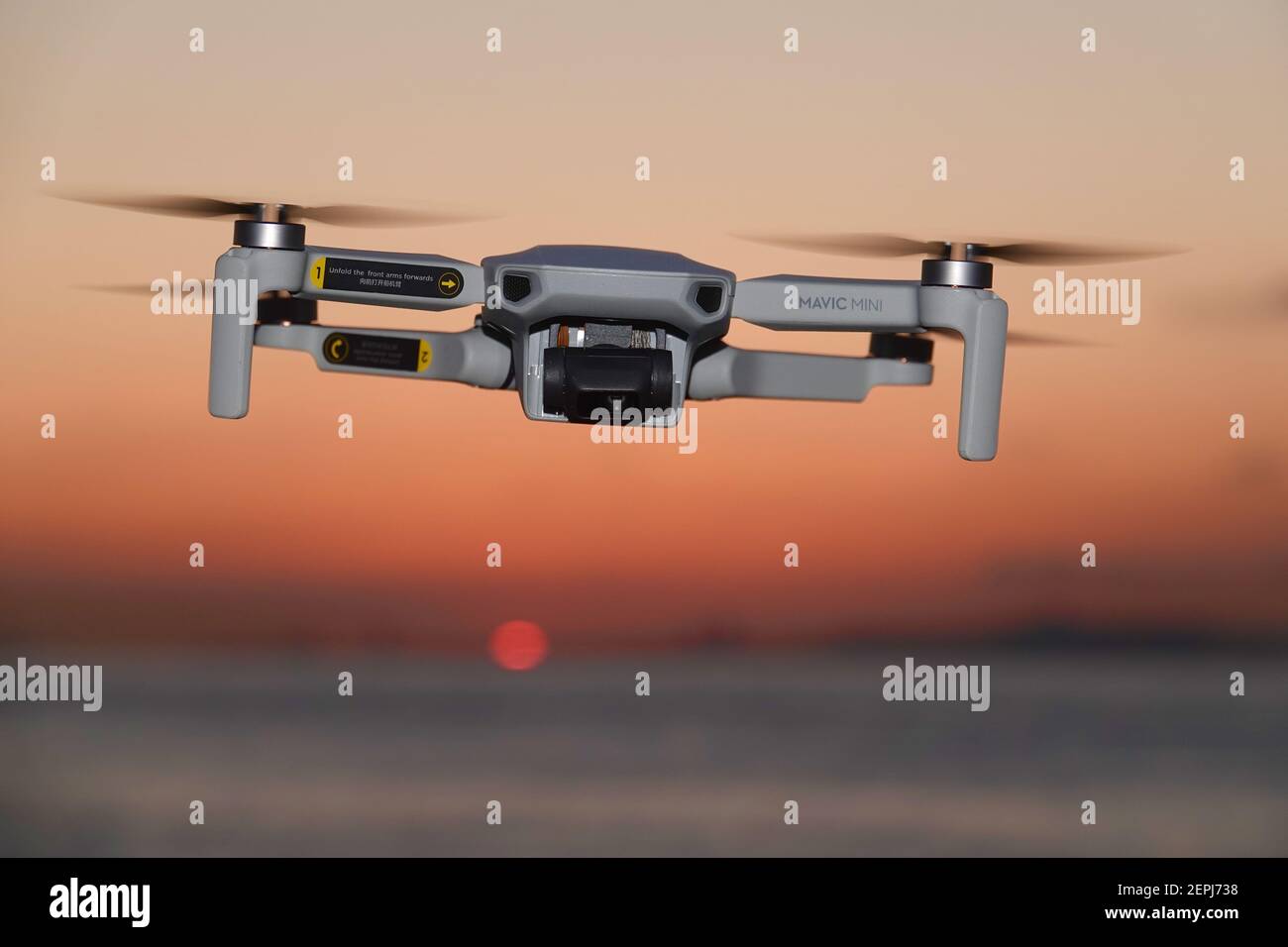 DJI Mavic Mini Drone flying at sunset Stock Photo