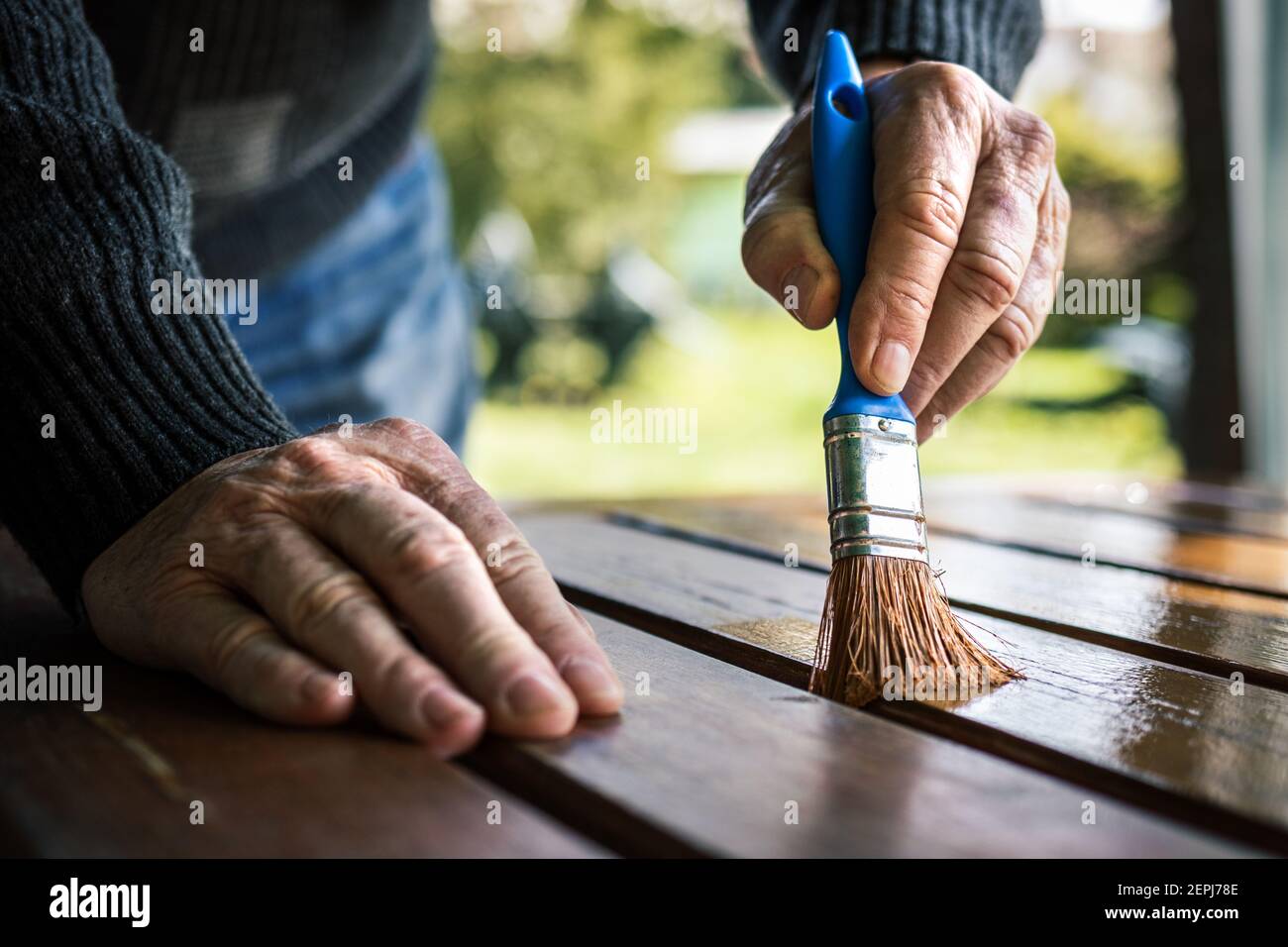 https://c8.alamy.com/comp/2EPJ78E/senior-man-painting-wooden-table-renovation-of-garden-furniture-close-up-hand-with-paintbrush-craftsman-is-restoring-furniture-outdoors-2EPJ78E.jpg